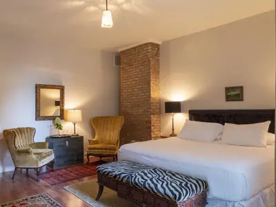 a bedroom with a large bed and two chairs at Stewart House Hotel in Athens