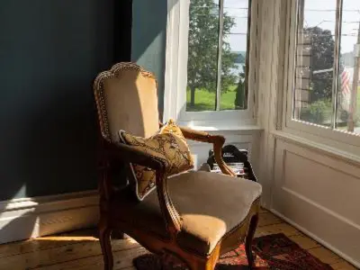 a rocking chair in a room with a window at Stewart House Hotel in Athens