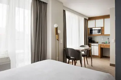 a hotel room with a bed and a table and a kitchen at TownePlace Suites by Marriott New York Long Island City in Queens