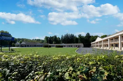 a campus with a green field and a building at Americas Best Value Inn at Central Valley-Woodbury in Central Valley