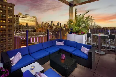 a blue couch on a rooftop with a city skyline at Fairfield Inn & Suites by Marriott New York Midtown Manhattan/Penn Station in New York