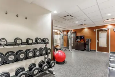 a gym with rows of dumbbells on the wall at Hampton Inn Manhattan Grand Central in New York