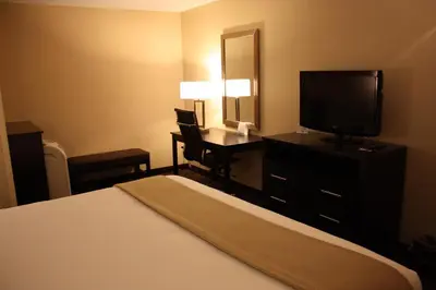 a hotel room with a bed and a desk with a television at Holiday Inn Express - Ludlow - Chicopee Area by IHG in Ludlow