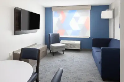 a living room with a couch and a tv at Holiday Inn Express - Ludlow - Chicopee Area by IHG in Ludlow