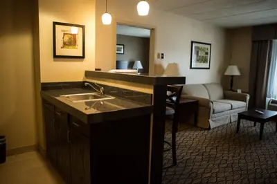 a hotel room with a sink and a living room at Holiday Inn Express Milford by IHG in Milford