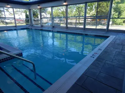 a swimming pool with blue water in a building at Holiday Inn Express Milford by IHG in Milford