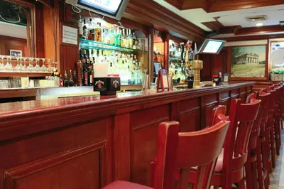 a bar with a row of chairs in a pub at Da Vinci Hotel in New York