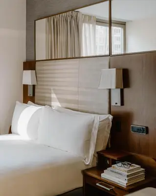 a hotel room with a bed and a night stand with a table with a bed at Club Quarters Hotel Grand Central, New York in New York