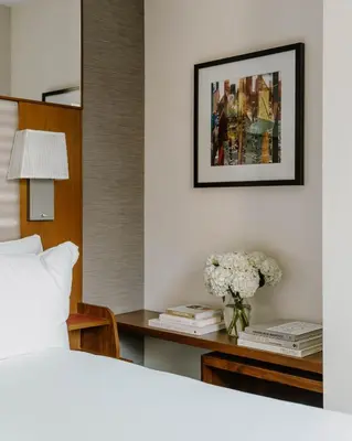 a bedroom with a bed and a table with a vase of flowers at Club Quarters Hotel Grand Central, New York in New York