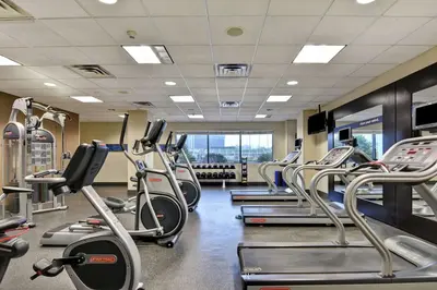 a gym with rows of treadmills and machines at Hampton Inn & Suites Newark-Harrison-Riverwalk in Newark