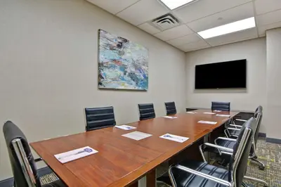 a conference room with a large wooden table and chairs at Hampton Inn & Suites Newark-Harrison-Riverwalk in Newark