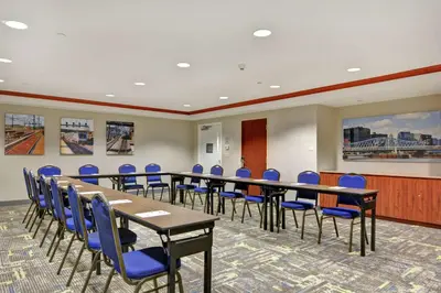 a conference room with tables and blue chairs at Hampton Inn & Suites Newark-Harrison-Riverwalk in Newark