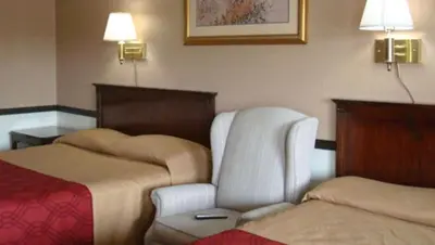 a hotel room with a chair and a bed at New Haven Inn in New Haven