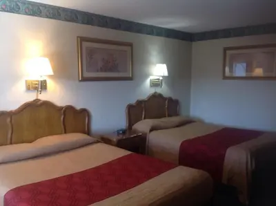 a hotel room with two beds and two lamps at New Haven Inn in New Haven