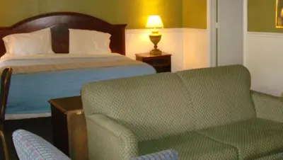 a hotel room with a bed and a couch and a chair at New Haven Inn in New Haven