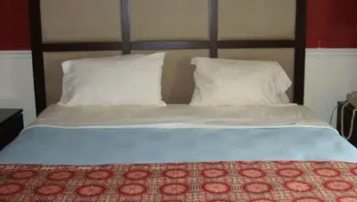 a bed with two white pillows at New Haven Inn in New Haven