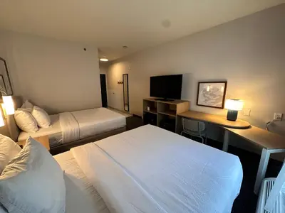 a hotel room with two beds and a desk and a television at Spark by Hilton Guilford in Guilford