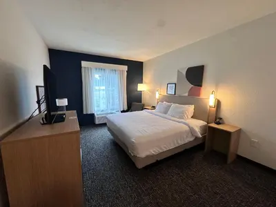 a hotel room with a bed and a flat screen tv at Spark by Hilton Guilford in Guilford