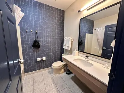a bathroom with a sink and a toilet and a mirror at Spark by Hilton Guilford in Guilford