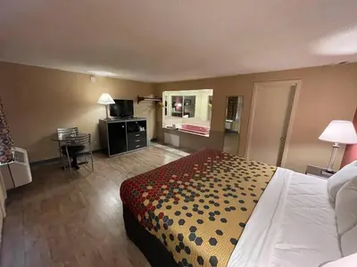 a hotel room with a bed and a desk at Economy Inn in East Hartford