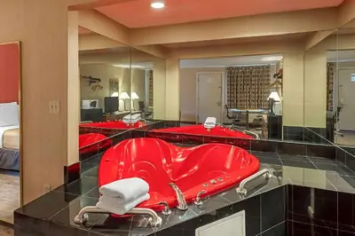 a red bath tub in a bathroom with red sinks at Economy Inn in East Hartford
