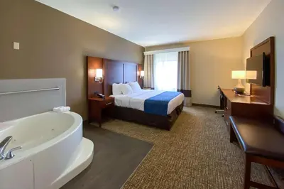 a hotel room with a bed and a bath tub at Comfort Inn East Windsor - Springfield in East Windsor