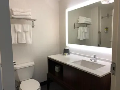 a bathroom with a sink and a toilet and a mirror at Holiday Inn Cheshire - Southington by IHG in Southington