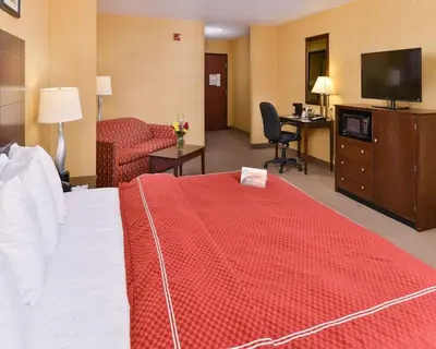 a hotel room with a bed with a red blanket at Quality Suites Stratford in Stratford