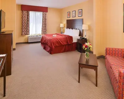 a hotel room with a bed and a couch at Quality Suites Stratford in Stratford