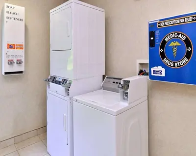 a refrigerator and a washer and dryer in a room at Quality Suites Stratford in Stratford