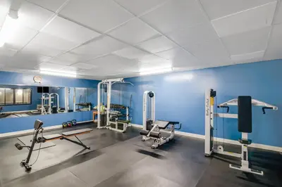 a gym with blue walls and several tread machines at Americas Best Value Inn Torrington, CT in Torrington