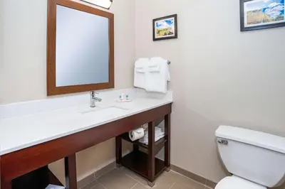 a bathroom with a sink and a toilet and a mirror at Comfort Inn Naugatuck-Shelton, CT in Naugatuck