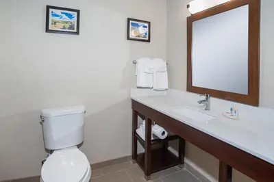 a bathroom with a toilet and a sink and a mirror at Comfort Inn Naugatuck-Shelton, CT in Naugatuck