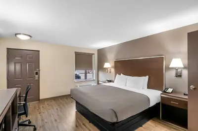 a hotel room with a large bed and a desk at Quality Inn Waterbury East in Waterbury