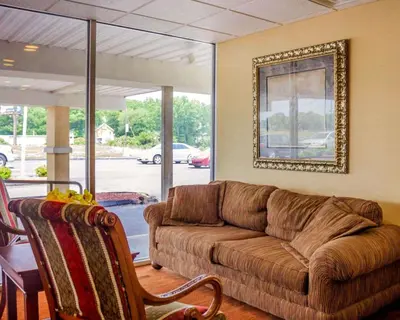 a living room with a brown couch and a table at Quality Inn Waterbury East in Waterbury