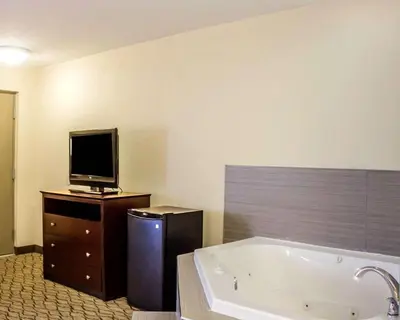 a bathroom with a tub and a tv on a dresser at Quality Inn Waterbury East in Waterbury