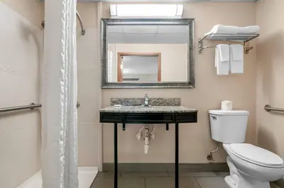 a bathroom with a sink and a toilet and a mirror at Quality Inn Waterbury East in Waterbury