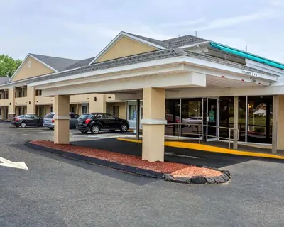 a building with cars parked in a parking lot at Quality Inn Waterbury East in Waterbury