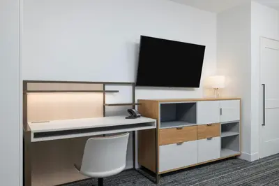 an office with a desk and a tv on a wall at TownePlace Suites by Marriott Hadley Amherst in Hadley