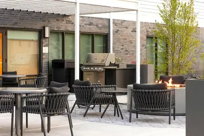 an outdoor patio with tables and chairs and a grill at TownePlace Suites by Marriott Hadley Amherst in Hadley