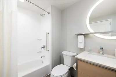 a white bathroom with a toilet and a sink at TownePlace Suites by Marriott Hadley Amherst in Hadley