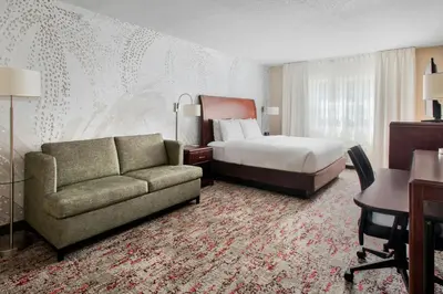 a hotel room with a bed and a couch at Fairfield Inn & Suites by Marriott Great Barrington Lenox/Berkshires in Great Barrington