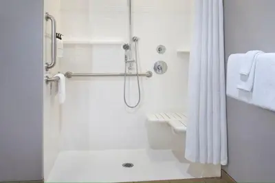 a white bathroom with a shower and a toilet at Fairfield Inn & Suites by Marriott Great Barrington Lenox/Berkshires in Great Barrington