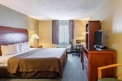 a hotel room with a bed and a flat screen tv at Quality Inn Chicopee-Springfield in Chicopee