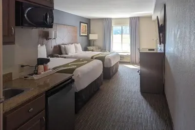 a hotel room with two beds and a sink at Quality Inn & Suites Northampton - Amherst in Northampton