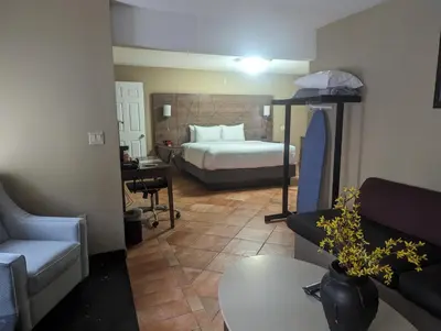 a hotel room with a bed and a living room at Quality Inn & Suites Northampton - Amherst in Northampton