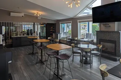 a restaurant with tables and chairs and a fireplace at Quality Inn & Suites Northampton - Amherst in Northampton