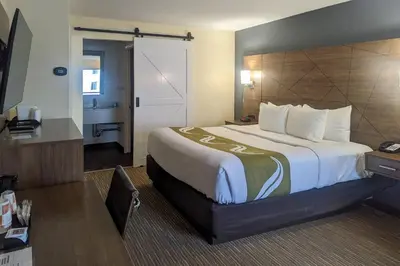 a hotel room with a large bed and a desk at Quality Inn & Suites Northampton - Amherst in Northampton