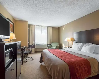 a hotel room with a bed with a red blanket at Comfort Inn Saugerties in Saugerties