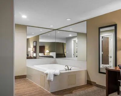 a large bathroom with a tub and a large mirror at Comfort Inn Saugerties in Saugerties